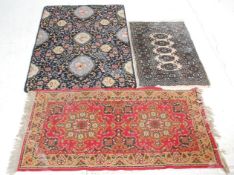 A mixed group of three rugs to include 100% wool black ground example with floral patterns, a