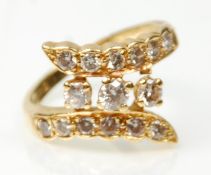 A hallmarked 18ct gold wrap around design dress ring set with three central diamonds, and two rows