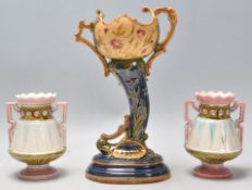 A garniture of three late 19th Century majolica vessels / vases to include a German cornucopia