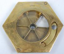 An early 20th Century patent brass countertop till of hexagonal form having a round glass panel with