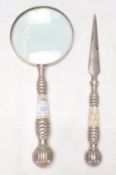 A 20th Century desktop magnifying glass having a white metal banded handle with inlaid mother of