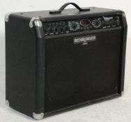 A Behringer V-ampire LX210 electric guitar amplifier having a digital display window, leather finish