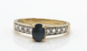 A 9ct gold, sapphire and diamond ring. The ring set with cabochon sapphire with diamond set