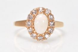 A 9ct gold Birmingham hallmarked opal and diamond ring. The cabochon opal within a halo of diamonds.