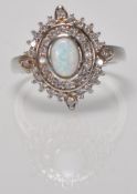 A stamped 925 silver panel ring having a central oval opal with concentric halo's of CZ's. Weight