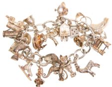 A good vintage English silver hallmarked charm bracelet adorned with many charms to include small