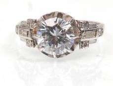 A platinum ladies dress ring set with a large central CZs stone with diamond accent stones to the