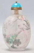 A 20th Century Chinese reverse painted scent bottle being decorated with birds and florals,