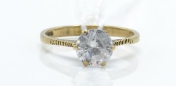 A hallmarked 9ct gold and white stone solitaire ring. The ring set with a mixed cut white stone with