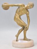 A 20th century cast brass figurine of a discus throwing olympian raised on a round marble base.