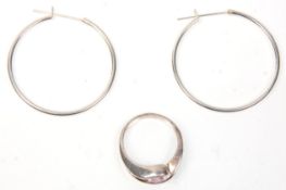 A pair of stamped 925 silver hoop earrings together with a silver cross over design ring set with