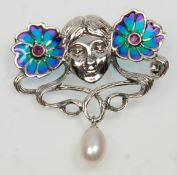 A stamped 925 silver Art Nouveau style brooch having a female face flanked by two plique a jour