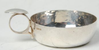 A silver hallmarked wine taster having hand beaten decoration. Inscription to base for 'Chris
