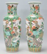 A pair of 19th Century Chinese famille verte porcelain baluster vases being hand enamelled over a