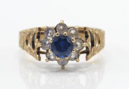A 9ct gold sapphire and diamond cluster ring. The central sapphire within a halo of diamonds.