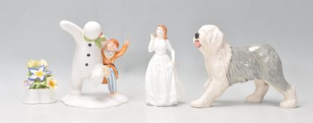 A group of four Royal Doulton figurines to include the snowman and James dancing in the snow (