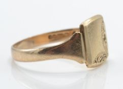 A 9ct gold signet ring. The plain cartouche  with chased edges to tapering shoulders and plain