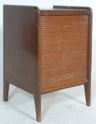 A mid century tambour fronted record hi-fi cabinet being raised on shaped legs with sectional