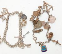 Two silver charm bracelets adorned with many charms. One vintage example having tourist shield