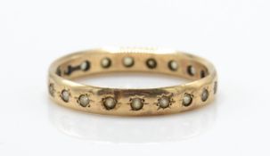 A 9ct gold full eternity ring. The ring inset with white stones to shaped band. Total weight 2.