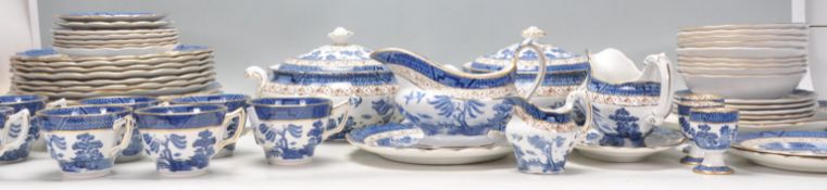 A large Booths 'Real Old Willow' service being transfer printed with blue and white decoration