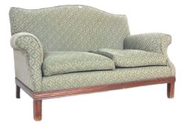 A 20th Century Howard Style upholstered two seater sofa settee having a shaped back with rolled