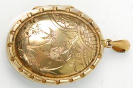 A large 19th century Victorian pinchbeck locket of oval form having engraved swallow decoration
