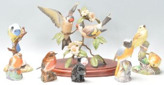 A collection of ceramic bird figurines to include a Royal Worcester Redstart, a Beswick Robin, a
