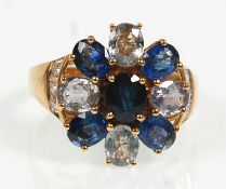 A hallmarked 9ct yellow gold ladies dress ring having various coloured oval faceted cut blue