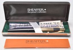 A vintage Sheaffer fountain ink pen in its original box with paper work, having a black plastic