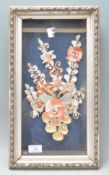 A lovely collection of framed and glazed shells forming a decorative flower of varying colors.