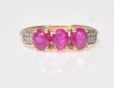 A 9ct gold ruby 3 stone ring. Stamped 375 with additional 10k mark. The 3 rubies within prong