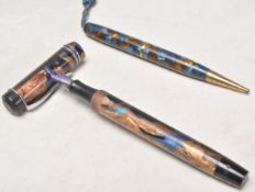 A pair of vintage 20th Century writing pens each having blue and brown mottled celluloid cases to