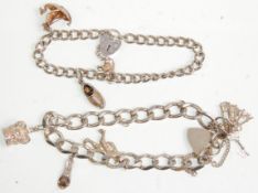 Two silver charm bracelets having silver heart padlock clasps. Adorned with charms to include a