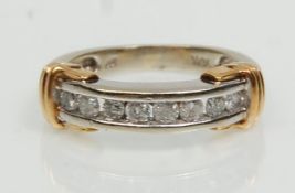 A stamped 9ct two tone gold half eternity ring channel set with eight round cut diamonds. Weight 3.