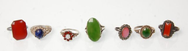 A group of seven silver rings to include a green stone panel ring (possibly jade) a lapis lazuli set