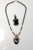 A twentieth century silver pendant necklace with a beaded black onyx chain and an oval onyx