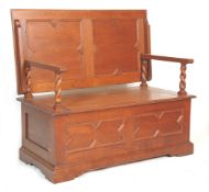 A 20th Century jacobean revival oak monks bench settle table having geometric mouldings and carved