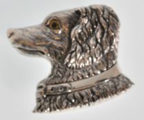 A stamped sterling silver brooch in the from of a red setter dog set with yellow glass eyes.