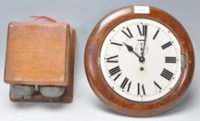 An early 20th Century station wall clock having a round white enamelled face with roman numeral to