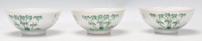 A set of three 19th Century Chinese footed bowls having a white ground enamelled with bamboo and