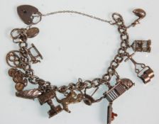 A silver charm bracelet adorned with many silver charms to include a cat playing with a ball, oil