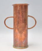 A vintage 20th Century copper twin handled vase of cylindrical form raised on a circular brass
