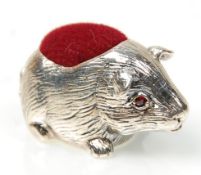 A stamped 925 silver pin cushion in the form of a guinea pig having a red velvet cushion to the