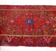 A lovely vintage 20th Century Persian / Islamic floor rug having red ground with pink, green and