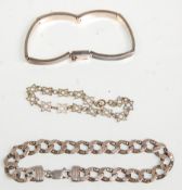 A group of three silver ladies bracelets to include a thick panel bracelet with engraved strip