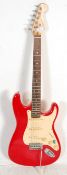 A Squier six string strat by Fender series electric guitar having a red body with white