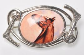 A stamped silver horse riding / equestrian brooch having a central oval panel enamelled with a