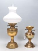 Two vintage 20th Century brass oil lamps with one having a white glass shade and funnel. Measures 51