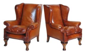 An excellent pair of 20th Century brown leather upholstered wingback chesterfield armchairs having